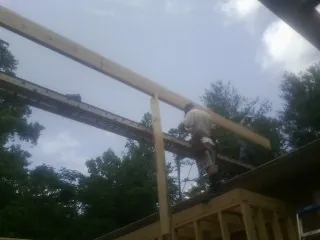 Carpenter setting a ridge beam over a new addition frame — Ice Dam Removal by Roofing Brothers in Katonah