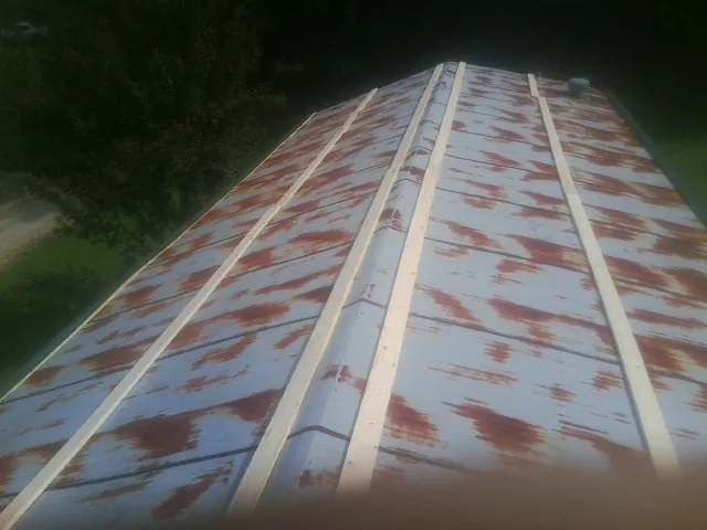 Rusted metal roof panels with new wood purlins before replacement — Storm Damage Roof Repair in Katonah by Roofing Brothers