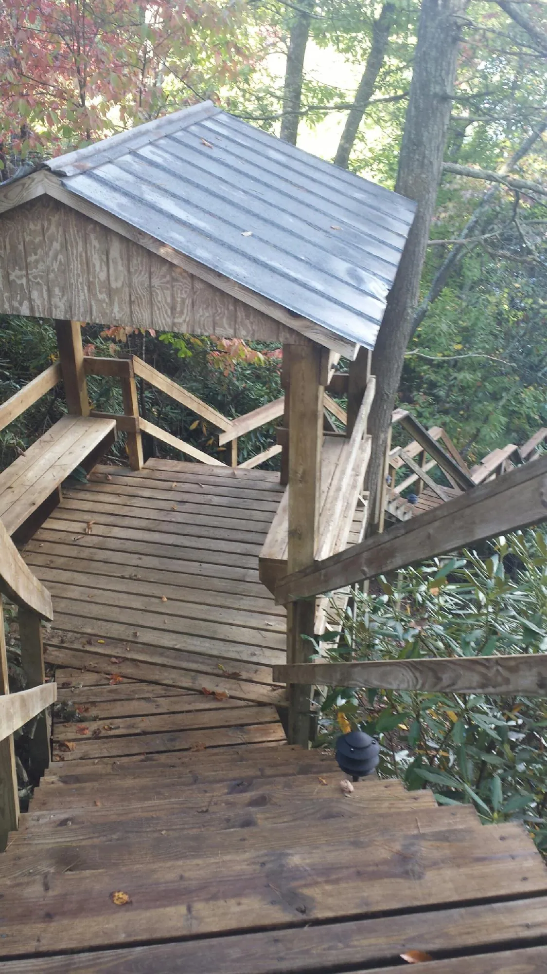 Metal roofed shelter over wooden steps on a wooded walkway — Skylight Repair & Installation work by our crew in Katonah